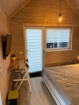 a bedroom with a bed and a desk and a window at Atostogu namelis in Anykščiai