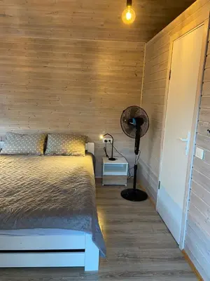 a bedroom with a bed and a desk with a lamp at Atostogu namelis in Anykščiai
