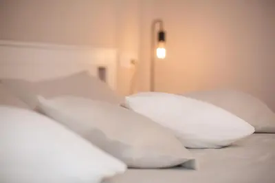 a row of white pillows sitting on a bed at Šviesus ir jaukus butas Šiaulių centre puiki vieta poilsiui #2 in Šiauliai