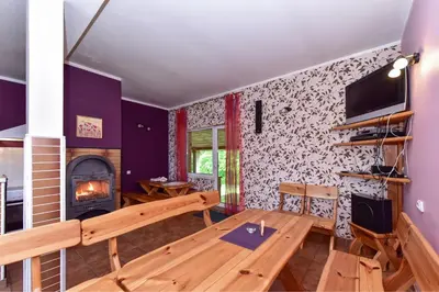 a living room with a wooden table and a fireplace at Lauryno sodyba in Suviekas