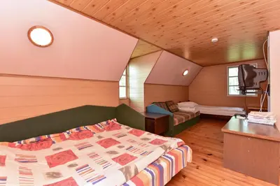 a bedroom with a bed and a tv in a room at Lauryno sodyba in Suviekas