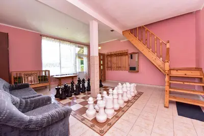a living room with a chess board and a staircase at Lauryno sodyba in Suviekas