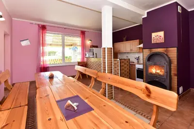 a living room with a wooden table and a fireplace at Lauryno sodyba in Suviekas