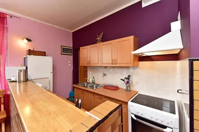 a kitchen with purple walls and a wooden counter top at Lauryno sodyba in Suviekas
