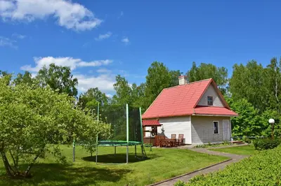 a house with a red roof with a ping pong table at Lauryno sodyba in Suviekas