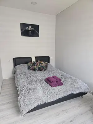 a bed with two purple pillows on top of it at Kaunas Pramogų kambarys in Kaunas