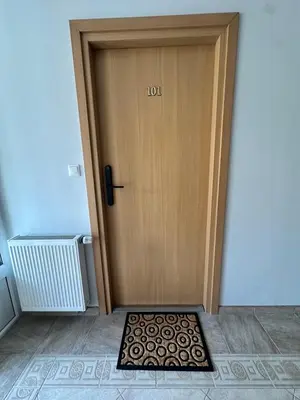 a wooden door with a mat in front of it at SILVIA apartment 101 in Druskininkai