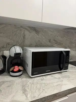 a microwave sitting on a counter next to a coffee maker at SILVIA apartment 101 in Druskininkai