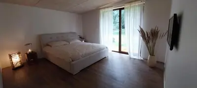 a bedroom with a bed and a large window at Mango namelis in Žuvininkai