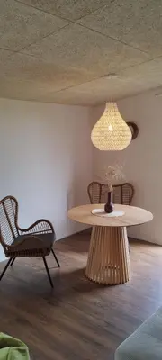 a table and a chair in a room with a lamp at Mango namelis in Žuvininkai