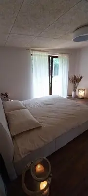 a bedroom with a large bed with a window at Mango namelis in Žuvininkai