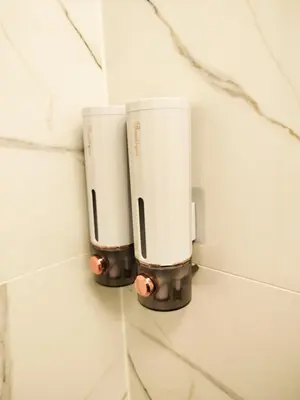 two white cups on a wall in a bathroom at Cozy Noko Apartments in Kaunas