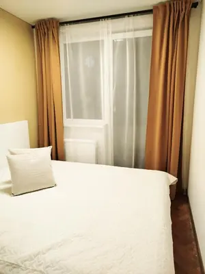 a bedroom with a white bed and a window at Cozy Noko Apartments in Kaunas