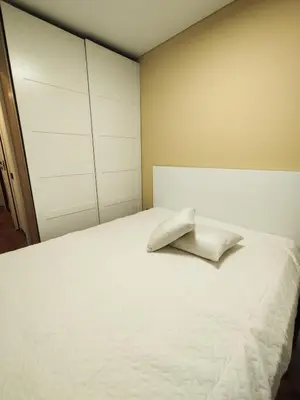 a bedroom with a white bed with a pillow on it at Cozy Noko Apartments in Kaunas