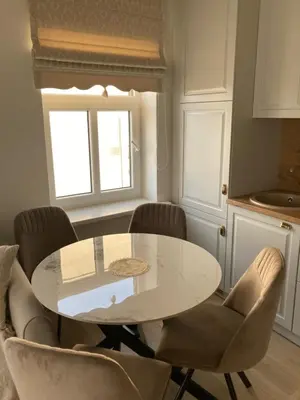 a dining room with a white table and chairs at Apartamentai Domus Antiqua in Zarasai