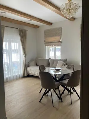 a living room with a table and chairs and a couch at Apartamentai Domus Antiqua in Zarasai