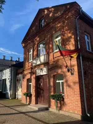 a red brick building with a flag on it at Apartamentai Domus Antiqua in Zarasai
