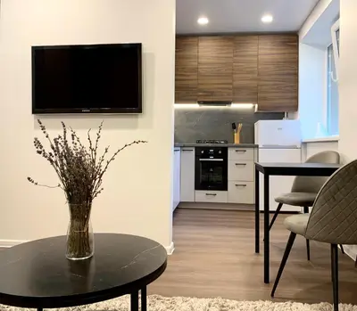 a living room with a vase of flowers on a table at Cozy Studio Apartment in the City Center in Šiauliai
