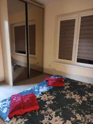 a bedroom with two red towels on a bed with a mirror at Rent Olamit in Karkazai