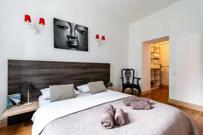 a bedroom with a large bed with a face on the wall at Gusto Apartment in Kaunas