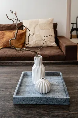 two white vases sitting on a tray in a living room at Gusto Apartment in Kaunas