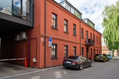 a orange building with cars parked in front of it at Gusto Apartment in Kaunas