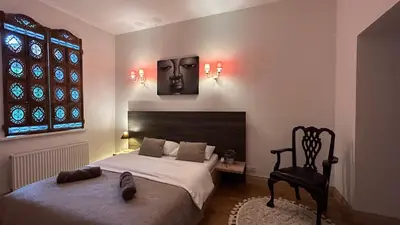a bedroom with a bed with a face on the wall at Gusto Apartment in Kaunas