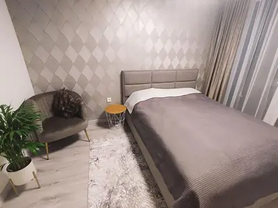 a bedroom with a bed and a chair and a plant at Kaunas Castle Apartment in Kaunas