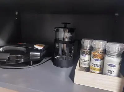 a counter with a coffee maker and jars of spices at Kaunas Castle Apartment in Kaunas