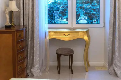 a dressing table with a stool under a window at Elegant Old Town Apartment with Terrace & Parking in Vilnius