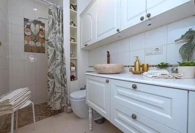 a white bathroom with a sink and a toilet at Elegant Old Town Apartment with Terrace & Parking in Vilnius
