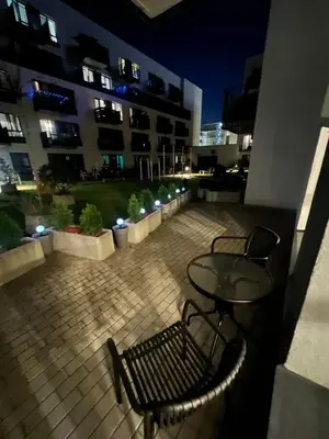 a patio with two chairs and a table and a building at Ozas Park Apartments in Vilnius