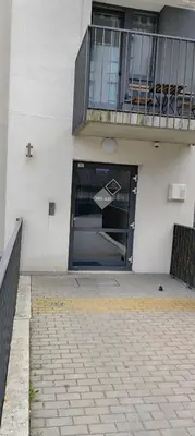 a building with a large door with a balcony at Ozas Park Apartments in Vilnius