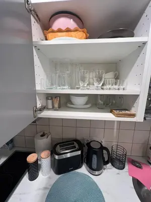 a cupboard filled with lots of dishes and glasses at Ozas Park Apartments in Vilnius