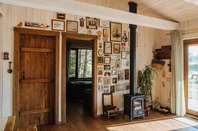 a room with a wood stove and a wall of pictures at Terra Gratia - namukas Išminčius in Nemeikšiai