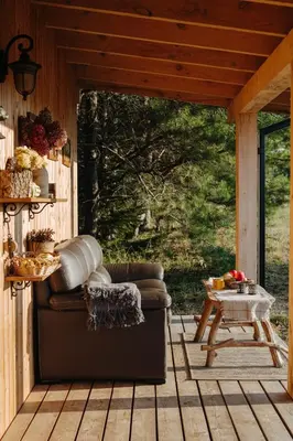 a living room with a couch on a porch at Terra Gratia - namukas Išminčius in Nemeikšiai