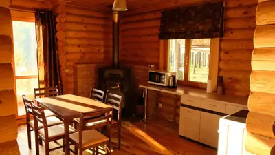 a kitchen with a table and chairs in a cabin at Namelis Pušyne in Pailgis