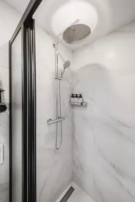 a shower with a glass door in a bathroom at Zveryno apartment in Vilnius