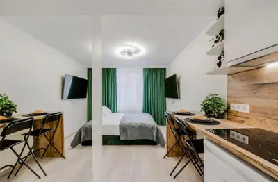 a bedroom with a bed and a kitchen with a desk at Zveryno apartment in Vilnius