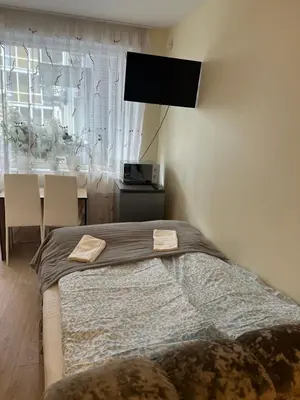 a bedroom with a bed and a table with chairs at A5 apartment in Vilnius