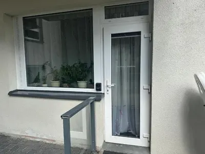 a white door with potted plants in a window at A5 apartment in Vilnius