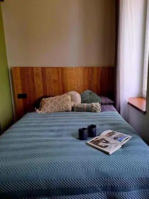 a bed with a book and two cups on it at Platforma2b eco in Šiauliai