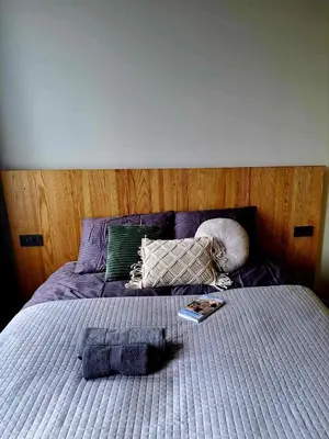 a bed with purple sheets and a book on it at Platforma2b eco in Šiauliai
