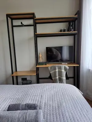 a bedroom with a bed and a desk and a tv at Platforma2b eco in Šiauliai