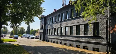 a brick building with windows on the side of a street at Platforma2b eco in Šiauliai
