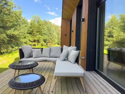 a patio with a couch and tables on a deck at IVIS House Lakeside Retreat in Vilnius in Vilnius