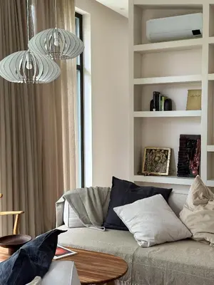 a living room with a couch and two chandeliers at IVIS House Lakeside Retreat in Vilnius in Vilnius