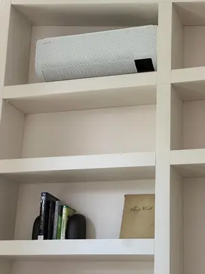 a book shelf with a speaker and books at IVIS House Lakeside Retreat in Vilnius in Vilnius