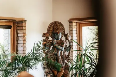 a wooden statue in a room with plants at Shanti Resort - Retreat & Wellness Center in Sarboriškės I