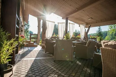 a restaurant with tables and chairs on a patio at Shanti Resort - Retreat & Wellness Center in Sarboriškės I